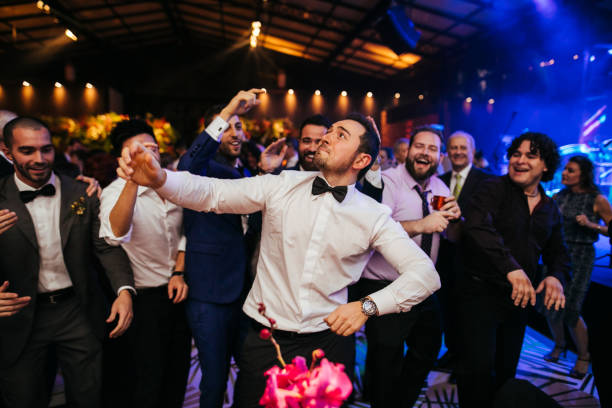 Groom and wedding guests laughing during party Groom and wedding guests laughing during party dance floor stock pictures, royalty-free photos & images