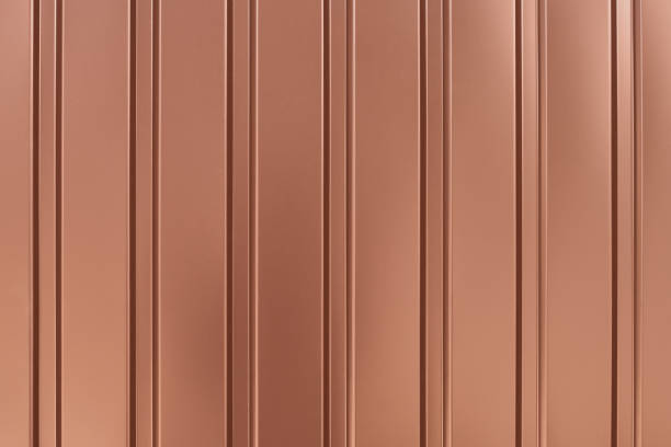 istock Light brown metallic striped surface. Gold background of metalline wall siding, cladding. Striated orange fence with shine, glitter. Reflecting metal convex texture. 1171740862