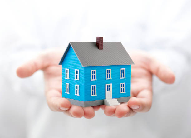 istock Small blue toy house in hands 1171743448