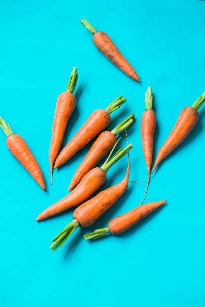 istock A few fresh carrots on blue background. 1171744562