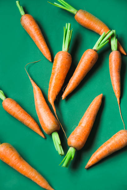 istock A few fresh carrots on green background. 1171744633