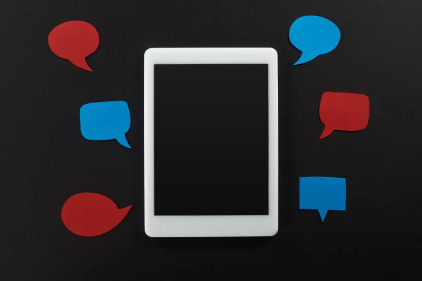 istock top view of digital tablet with blank screen on black background with empty red and blue speech bubbles, cyberbullying concept 1171745981