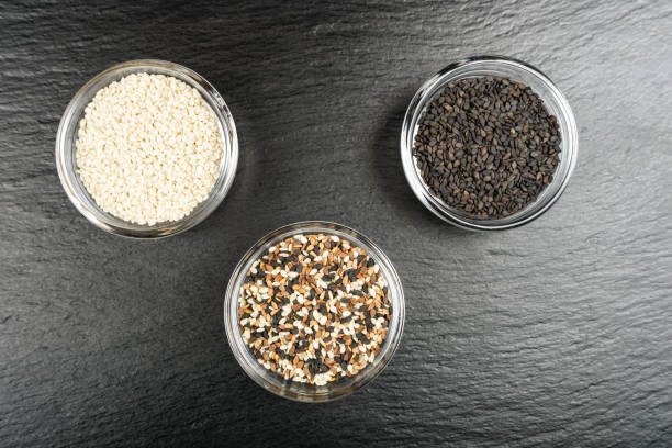 istock Sesame seeds in glass containers on a black stone background. 1171746279
