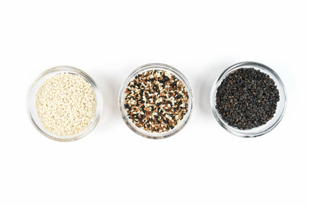 Sesame seeds in glass containers on a white background. Three different species.