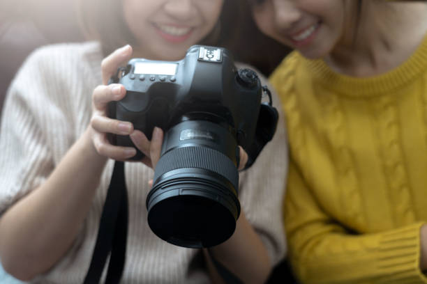 istock photographer holding a digital camera is composing the image and taking the picture. 1171746819