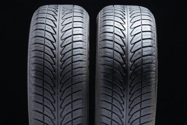 istock Two old summer tires used on black background 1171747620