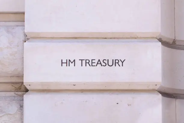 Simple carved lettering of HM (Her Majesty’s) Treasury, sometimes referred to as the Exchequer, or more informally the Treasury, outside the main entrance in London, UK