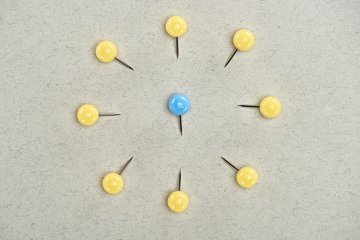 top view of pins symbolizing victim and abusers on grey background