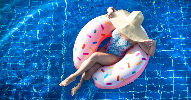 istock A woman in a hat relaxes on an inflatable circle in the pool. 1171748702