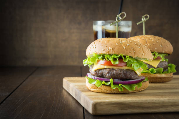 istock Beef burger with drink on wooden board. Close up. Horizontal orientation. Space for text. 1171749577