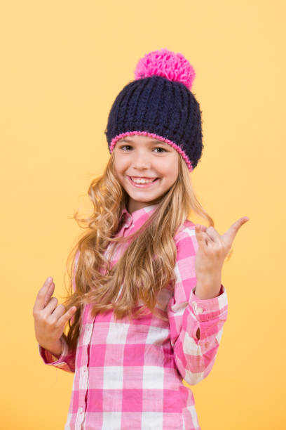 istock Child with long blond hair smile with horn hands 1171749747