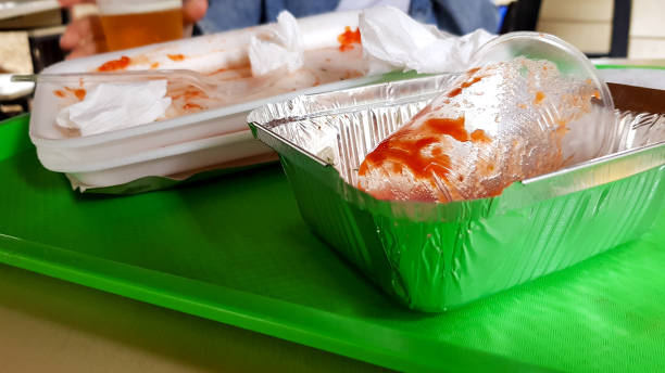 屋外カフェのテーブルの上の緑色のトレイの上の残り物、汚れたプラスチック皿 - dirty paper paper plate food ストックフォトと画像