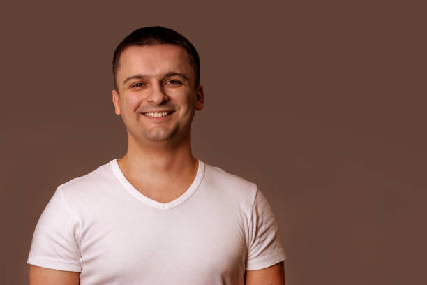 istock Smiling man in white t-shirt. Gray background. 1171753461