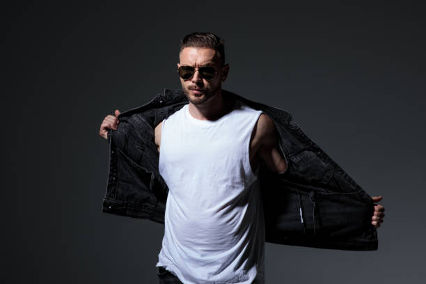 istock cool young muscular man takes off his jeans vest 1171754229