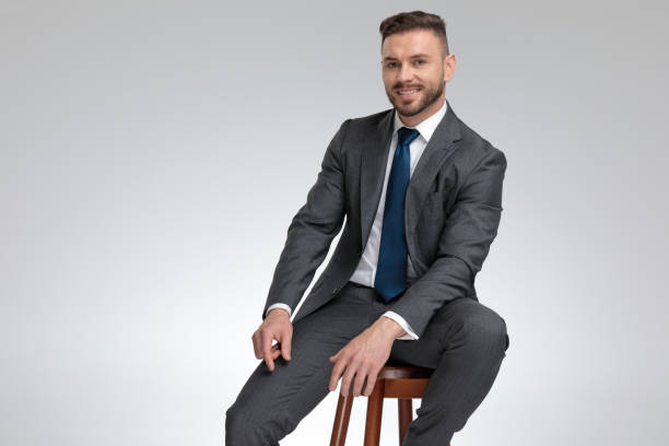 istock positive young businessman smiles while sitting on a stool 1171755014