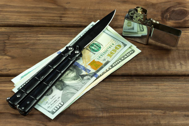 istock knife, lighter and money on a wooden table 1171756229