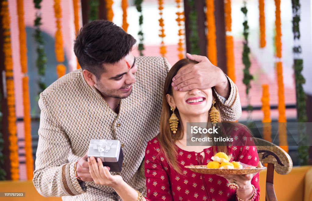 Surprise gift for sister Man with surprise gift for his sister on the occasion of traditional Indian festival Brother Stock Photo