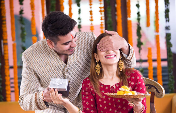 Surprise gift for sister Man with surprise gift for his sister on the occasion of traditional Indian festival sister stock pictures, royalty-free photos & images