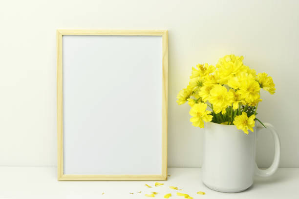 istock Frame mockup with yellow flowers in vase on white background. 1171757418