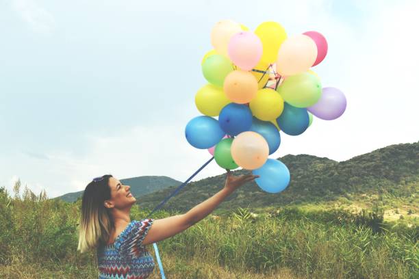 istock Young woman holding balloons 1171760550