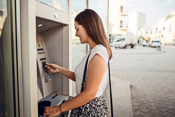 Woman withdrawing money at the outdoor ATM Woman withdrawing money at the ATM atm photos stock pictures, royalty-free photos & images