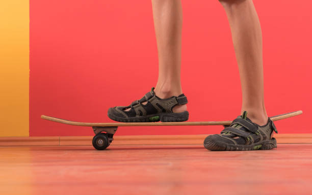 istock Young boy standing on skateboard in front of colored wall 1171766271