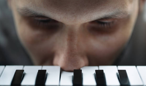Sad musician pushes a note B on the piano with his nose