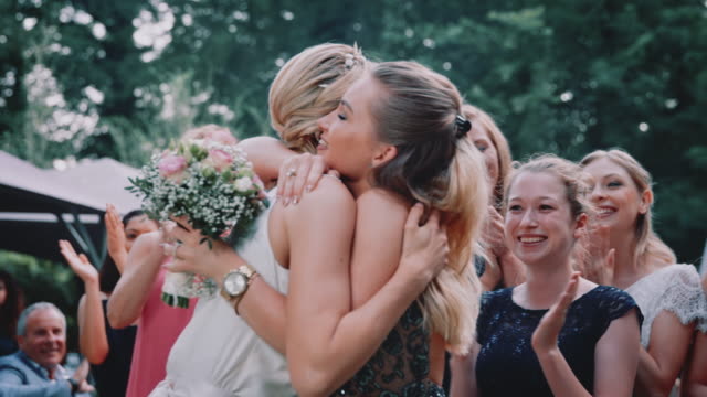 Bride throwing flower bouquet to guests in wedding