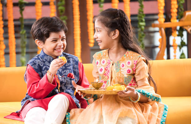 Boy feeding sweet food to his sister Little brother feeding sweet food to his sister on the occasion of Raksha Bandhan festival rakhi stock pictures, royalty-free photos & images