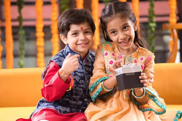 Loving brother and sister with gift box celebrating traditional Indian festival