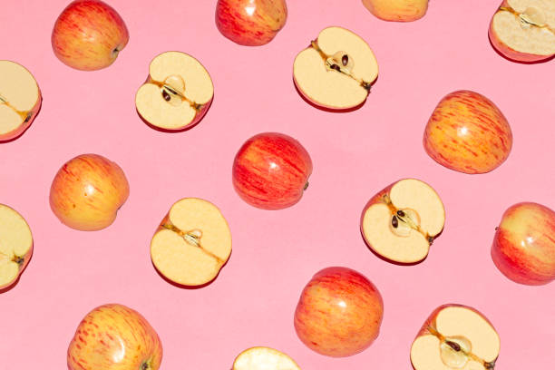 istock Fresh red and yellow apples pattern on pink background 1171776594