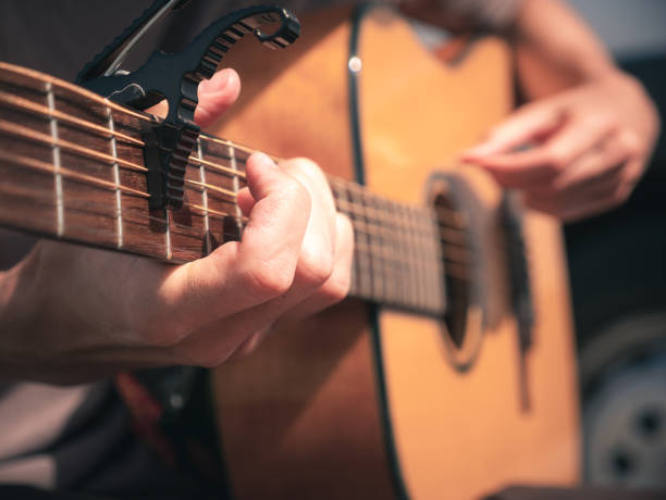 istock Close up hands on the strings of a lefty guitar with capo. 1171781048