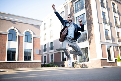 Happy College student man run and jump with blue sky background, full length, asian male