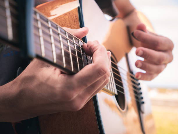 istock Close up hands on the strings of a lefty guitar with capo. 1171781675