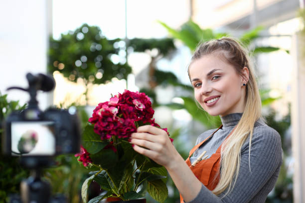 istock Smiling Blogger Touching Red Hydrangea Photo 1171783523