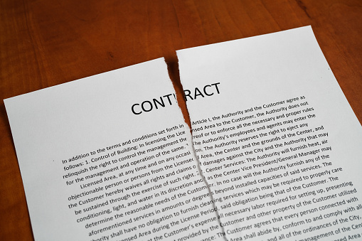 Torn up contract on a wooden desk