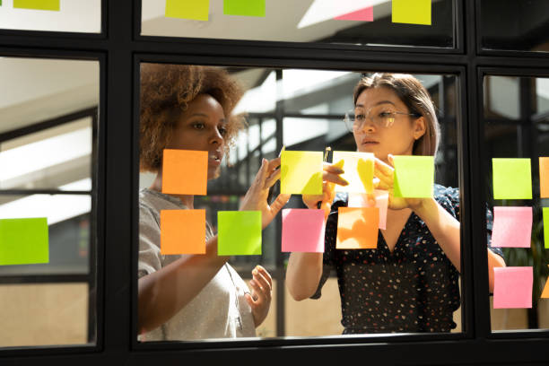 istock Serious african and asian female coworkers working with sticky notes 1171786288