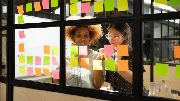istock Happy african and asian businesswomen working with sticky notes 1171786291