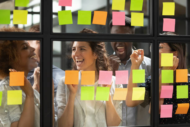 istock Overjoyed diverse business team stand behind glass with sticky notes 1171786301