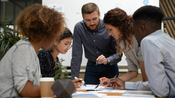 istock Focused multiethnic business people work together discuss paperwork at meeting 1171786315