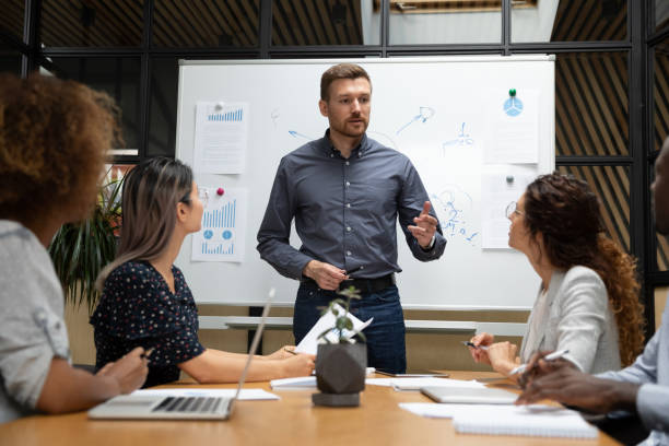 Confident businessman executive talk to employees during corporate briefing