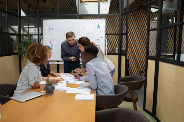 istock Busy diverse staff group gather in boardroom brainstorm on paperwork 1171786322