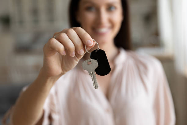 istock Close up focus on female hand holding key from house 1171789071