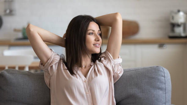 istock Beautiful young woman resting on couch looking away 1171789077