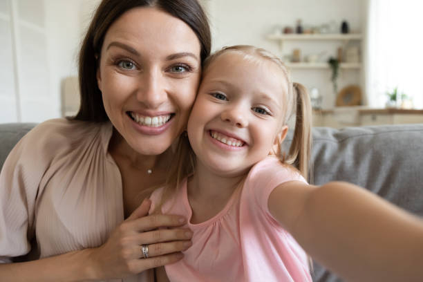 istock Webcam view daughter and mother sitting on couch at home 1171789143