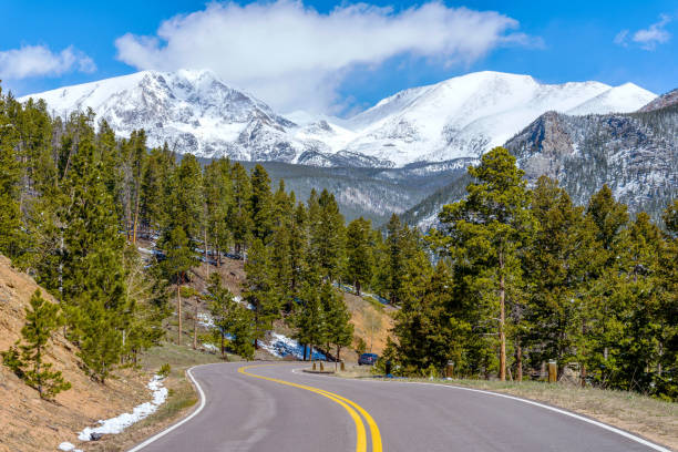 istock Spring Mountain Road - A Spring view of winding Fall River Road (Highway 34), with snow-capped Ypsilon Mountain and Fairchild Mountain of Mummy Range towering in background, Rocky Mountain National Park, CO, USA. 1171791184