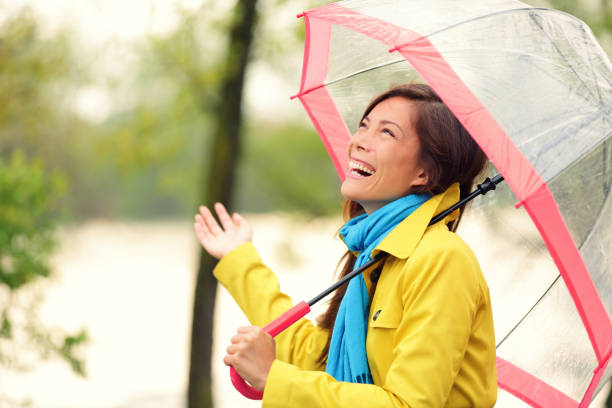 istock Woman happy with umbrella under the rain 1171795127