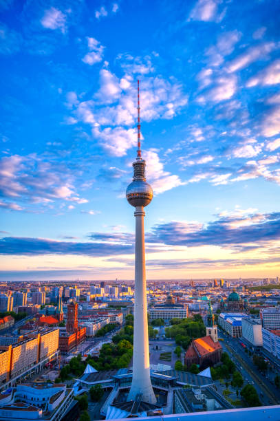 The Fernsehturm and Berlin, Germany at sunset A view of the television tower (Fernsehturm) over the city of Berlin, Germany at sunset. berlin germany urban road panoramic germany stock pictures, royalty-free photos & images