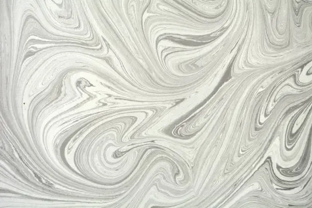 Photo of Abstract background. Ink marbling texture. Grey and white. Hand drawn marble illustration, ebru aqua paper and silk print. Traditional Turkish ebru technique. Painting on water.