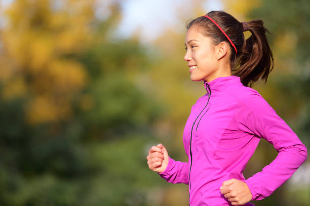 istock Asian woman running in autumn forest in fall 1171799575